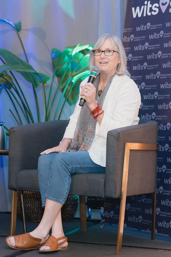 Julie Thorner on stage at WITS speaking with two other women.